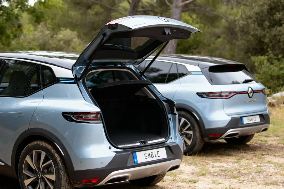 Deux voitures bleues Renault avec coffre ouvert, en plein air, sous des arbres. Plaques immatriculation visibles.