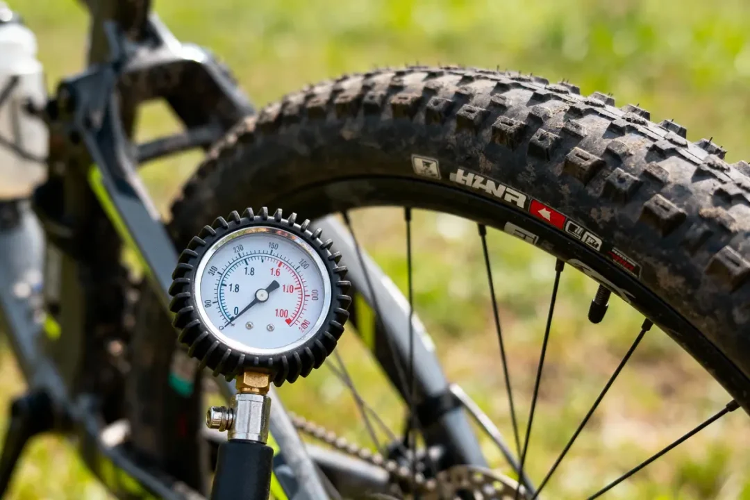 Gros plan d’un manomètre mesurant la pression d'un pneu de vélo tout-terrain, en extérieur.