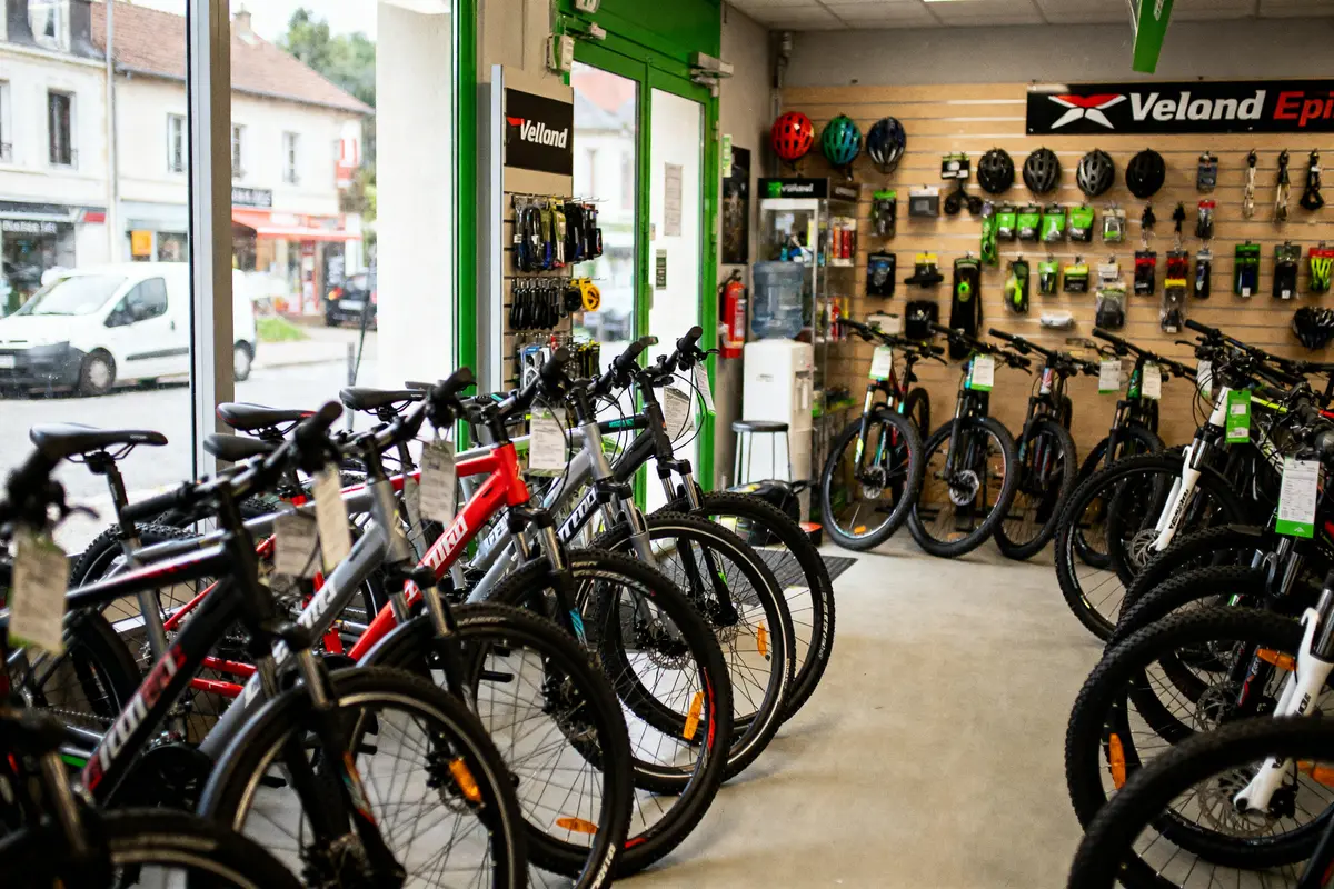 Magasin de vélos avec plusieurs modèles exposés, équipements de cyclisme accrochés au mur.