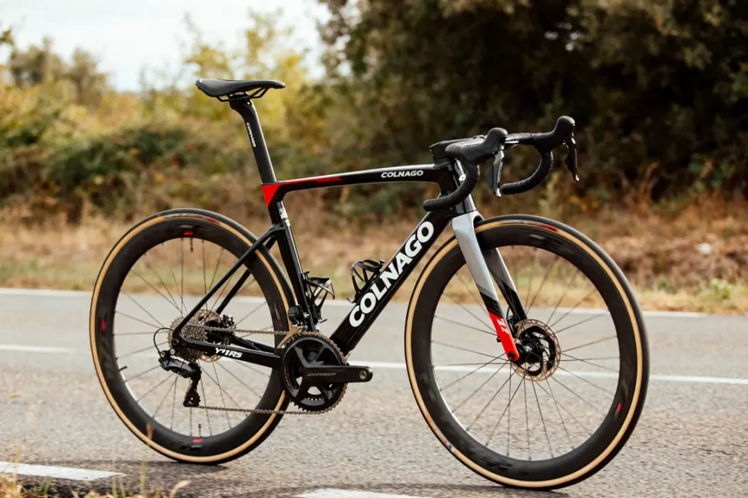Vélo route Colnago Y1RS noir et rouge stationné sur une route arbres en arrière-plan