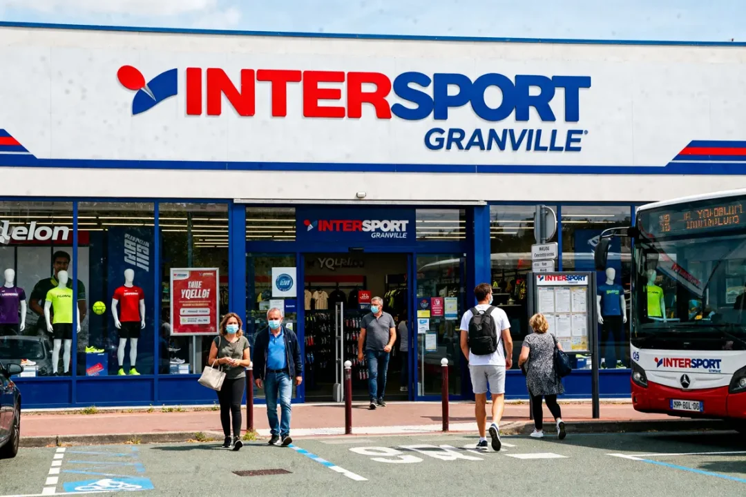 Foule devant le magasin Intersport Granville avec bus et mannequins en vitrine