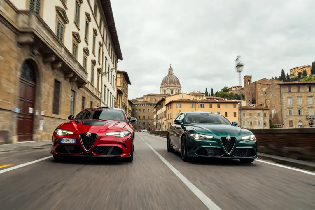 Deux Alfa Romeo 6 Underground rouges et vertes roulant dans une rue italienne historique