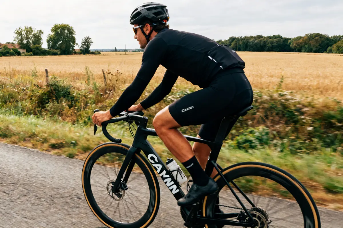 Cycliste pédalant sur route avec vélo Canyon Bike Company en campagne verdoyante