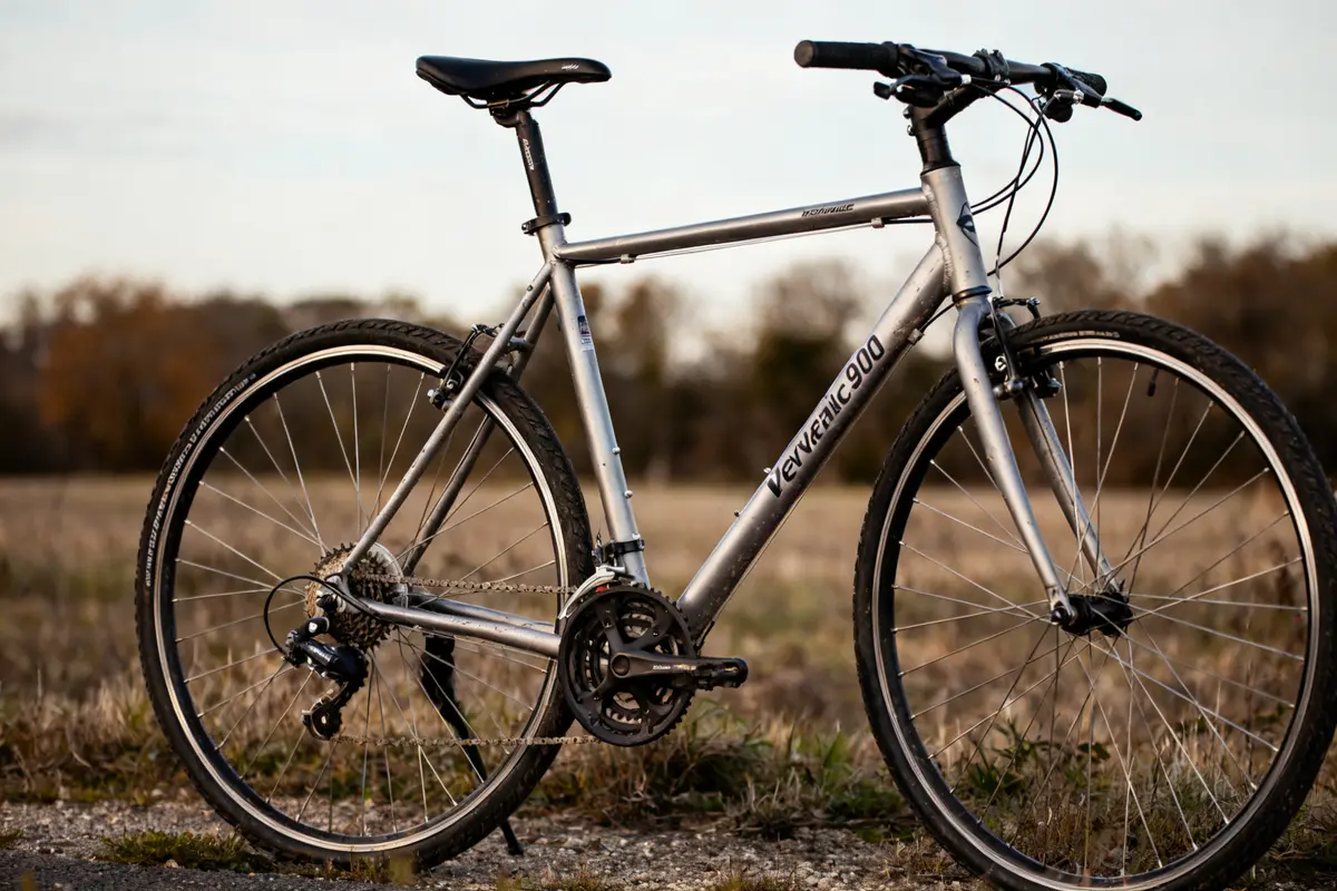 Vélo Riverside 900 gris dans un champ ensoleillé avec herbe sèche et ciel bleu