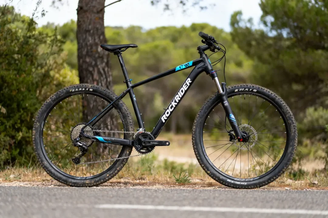 Vélo tout-terrain Rockrider ST 100 noir stationné sur un chemin forestier