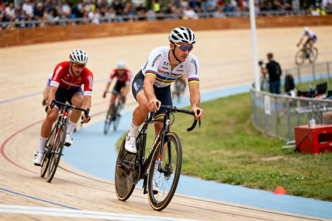 Cyclistes en compétition sur piste vététiste avec maillot XCC devant un public rempli