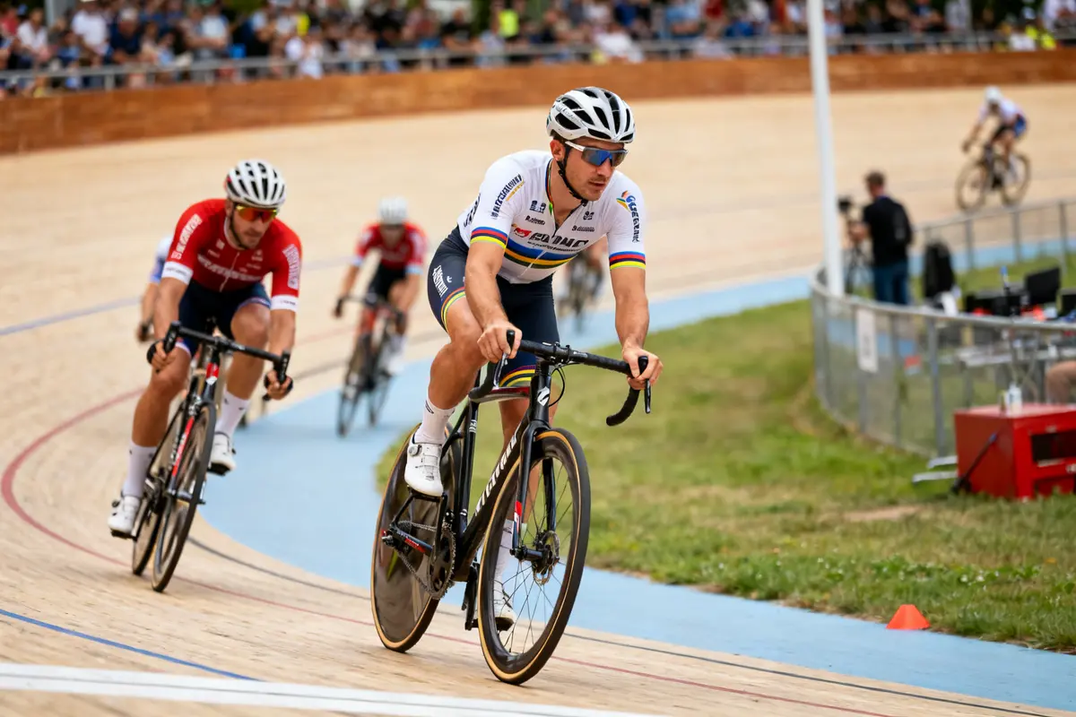Cyclistes en compétition sur piste vététiste avec maillot XCC devant un public rempli