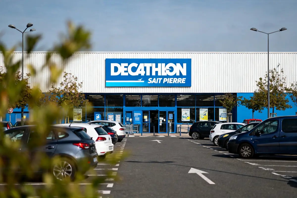 Façade du magasin Decathlon Saint Pierre avec parking rempli de voitures devant l'entrée
